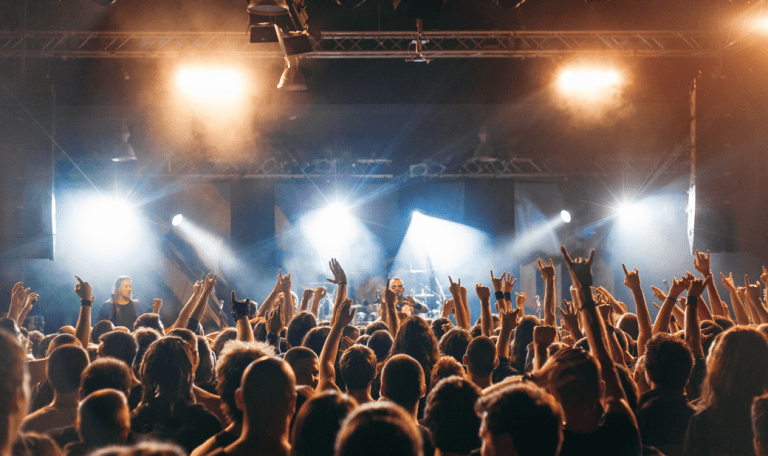 A concert with people with there hands in the air.